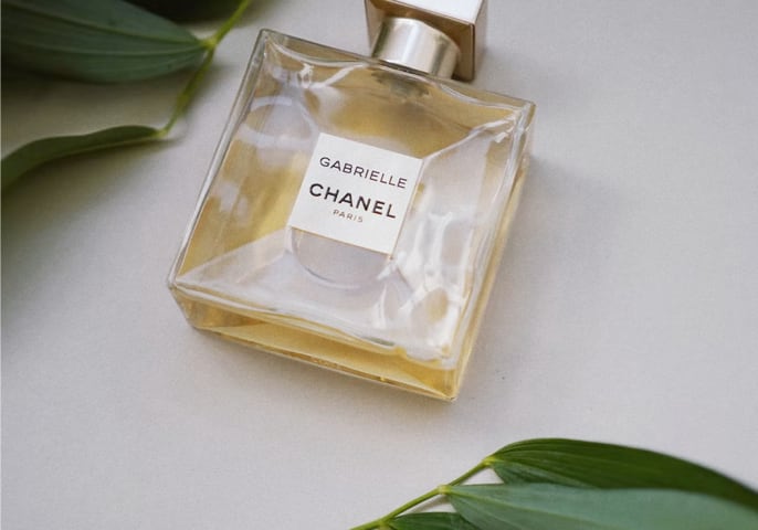 a perfume bottle of Gabrielle Chanel lying horizontally on a table